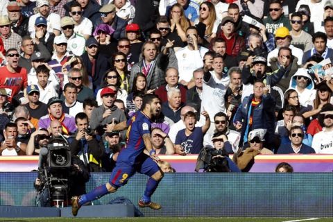 Barcelona's Luis Suarez celebrates after scoring the opening goal during the Spanish La Liga soccer match between Real Madrid and Barcelona at the Santiago Bernabeu stadium in Madrid, Spain, Saturday, Dec. 23, 2017. (AP Photo/Francisco Seco)