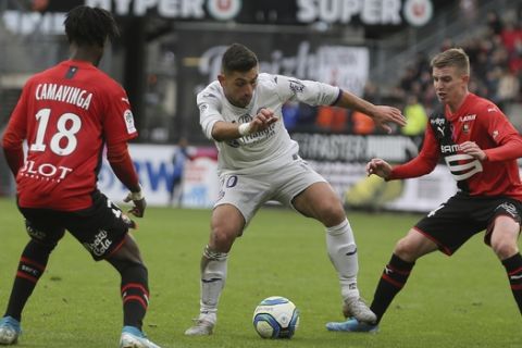 Greek forward Efthymios Koulouris challenges for the ball with Rennes' Benjamin Bourigeaud during the League One soccer match between Rennes and Toulouse, at the Roazhon Park stadium in Rennes, France, Sunday, Oct. 27, 2019. (AP Photo/David Vincent)