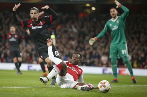 Arsenal's Danny Welbeck, center, falls as AC Milan's Ricardo Rodriguez, left and goalkeeper Gianluigi Donnarumma gestures during the Europa League round of 16 second leg soccer match between Arsenal and AC Milan at the Emirates stadium in London, Thursday, March, 15, 2018. (AP Photo/Alastair Grant)