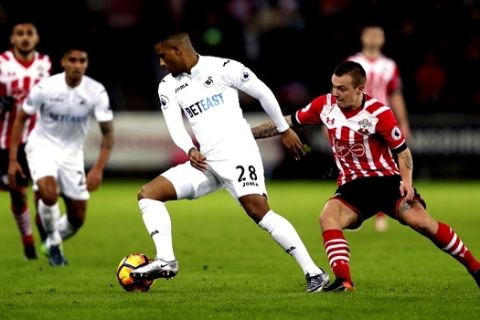 Swansea City's Luciano Narsingh, left, and Southampton's Jordy Clasie battle for the ball during their English Premier League soccer match at the Liberty Stadium, Swansea, Wales, Tuesday, Jan. 31, 2017. (David Davies/PA via AP)