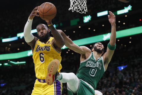 Los Angeles Lakers' LeBron James (6) and Boston Celtics' Jayson Tatum (0) battle for a rebound during the first half of an NBA basketball game, Friday, Nov. 19, 2021, in Boston. (AP Photo/Michael Dwyer)