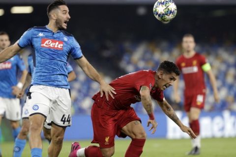Napoli's Kostas Manolas, left, and Liverpool's Roberto Firmino fight for the ball during the Champions League Group E soccer match between Napoli and Liverpool, at the San Paolo stadium in Naples, Italy, Tuesday, Sept. 17, 2019. (AP Photo/Gregorio Borgia)
