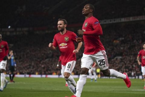 Manchester United's Odion Ighalo, front, celebrates with teammates after scoring his side's second goal during the round of 32 second leg Europa League soccer match between Manchester United and Brugge at Old Trafford in Manchester, England, Thursday, Feb. 27, 2020. (AP Photo/Dave Thompson)