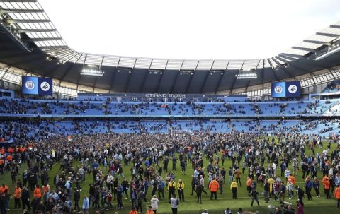 Manchester City fans invade the pitch after winning the English Premier League soccer match between Manchester City and Swansea City 5-0 at Etihad stadium in Manchester, England, Sunday, April 22, 2018. (Nigel French/PA via AP)