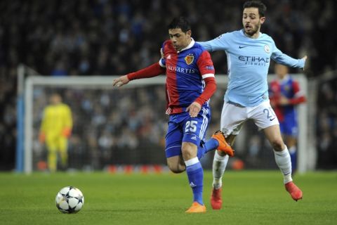 Basel's Blas Riveros, left, challenges for the ball with Manchester City's Bernardo Silva during the Champions League, round of 16, second leg soccer match between Manchester City and Basel at the Etihad Stadium in Manchester, England, Wednesday, March 7, 2018. (AP Photo/Rui Vieira)