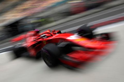 Ferrari driver Sebastian Vettel of Germany returns to his team's garage during the first practice session for the Chinese Formula One Grand Prix at the Shanghai International Circuit in Shanghai, Friday, April 13, 2018. (AP Photo/Andy Wong)