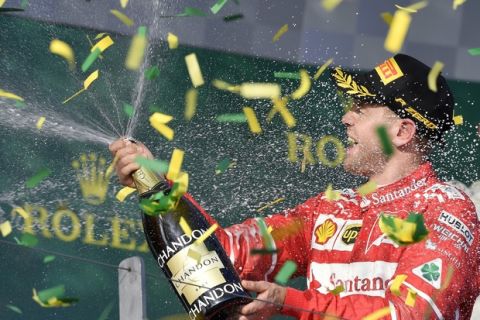 Ferrari driver Sebastian Vettel of Germany sprays champagne as confetti falls around him after winning the Australian Formula One Grand Prix in Melbourne, Australia, Sunday, March 26, 2017. (AP Photo/Andy Brownbill)