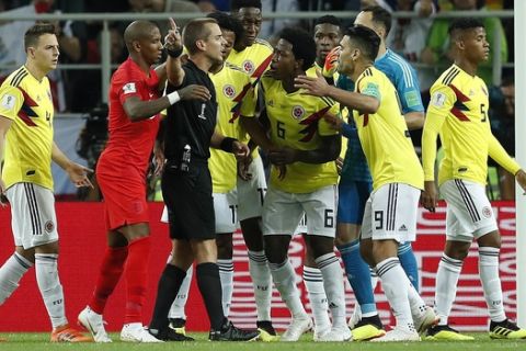 Colombia players argue with referee Mark Geiger from the US during the round of 16 match between Colombia and England at the 2018 soccer World Cup in the Spartak Stadium, in Moscow, Russia, Tuesday, July 3, 2018. (AP Photo/Alastair Grant)