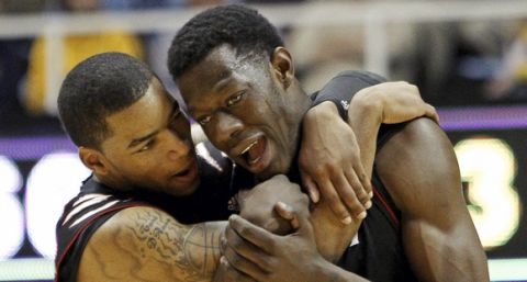 Cincinnati's Dion Dixon and Justin Jackson (5) talk near the end of the second half of an NCAA college basketball game against West Virginia in Morgantown, W.Va., on Saturday, Jan. 21, 2012. West Virginia won 77-74 in overtime. (AP Photo/David Smith)