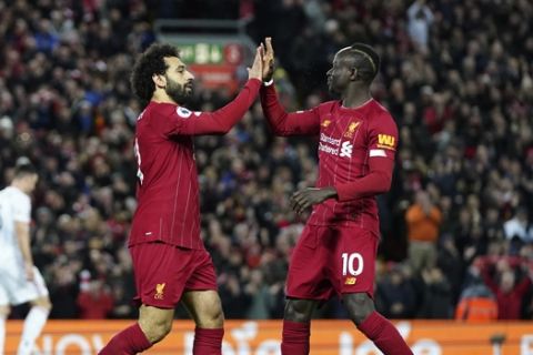 Liverpool's Mohamed Salah, front left, celebrates with Liverpool's Sadio Mane after scoring his side's opening goal during the English Premier League soccer match between Liverpool and Sheffield United at Anfield Stadium, Liverpool, England, Thursday, Jan. 2, 2020. (AP Photo/Jon Super)