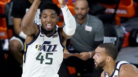 Utah Jazz's Donovan Mitchell (45) passes the ball as teammate Rudy Gobert, center, and moves up court against Denver Nuggets' Jerami Grant (9) during the first half of an NBA basketball first round playoff game, Monday, Aug. 17, 2020, in Lake Buena Vista, Fla. (AP Photo/Ashley Landis, Pool)