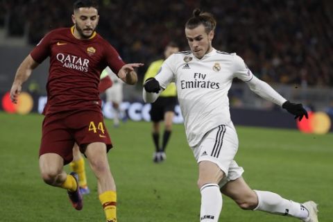Real midfielder Gareth Bale, right, runs with the ball as he is followed by Roma defender Kostas Manolas during a Champions League, Group G soccer match between Roma and Real Madrid at the Rome Olympic stadium, Tuesday, Nov. 27, 2018. (AP Photo/Andrew Medichini)