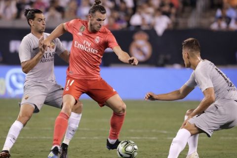 Real Madrid forward Gareth Bale, center, tries to control the ball against Roma midfielder Javier Pastore, left, and forward Patrik Schick during the second half of an International Champions Cup tournament soccer match, Tuesday, Aug. 7, 2018, in East Rutherford, N.J. Real Madrid won 2-1. (AP Photo/Julio Cortez)