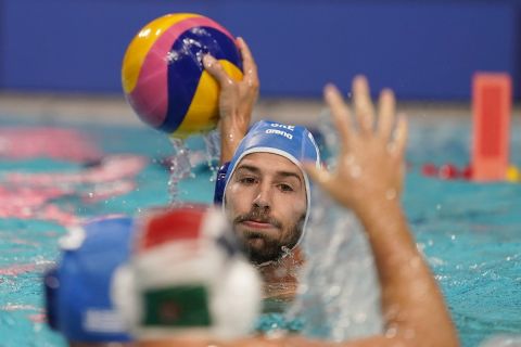 Greece's Angelos Vlachopoulos looks for an open teammate during a preliminary round men's water polo match against Hungary at the 2020 Summer Olympics, Sunday, July 25, 2021, in Tokyo, Japan. (AP Photo/Mark Humphrey)