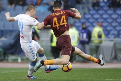 Napoli's Marko Rog, left, is challenged by Roma's Kostas Manolas during a Serie A soccer match at the Rome Olympic stadium, Saturday, March 4, 2017. (AP Photo/Gregorio Borgia)
