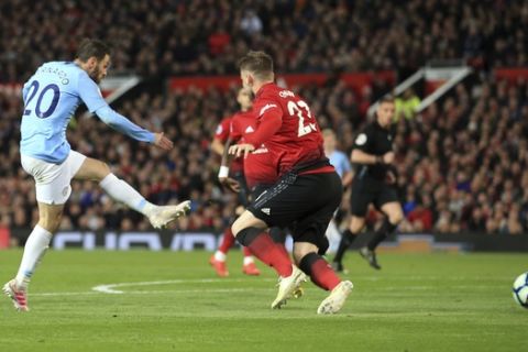 Manchester City's Bernardo Silva, left, scores the opening goall during the English Premier League soccer match between Manchester United and Manchester City at Old Trafford Stadium in Manchester, England, Wednesday April 24, 2019. (AP Photo/Jon Super)