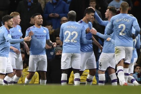 Manchester City's Rodrigo, centre, is congratulated by teammates after scoring his team's first goal during the English Premier League soccer match between Manchester City and West Ham at Etihad stadium in Manchester, England, Wednesday, Feb. 19, 2020. (AP Photo/Rui Vieira)