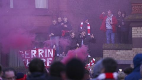 Liverpool supporters cheer as the bus carrying the team arrives for a second leg, round of 16, Champions League soccer match between Liverpool and Atletico Madrid at Anfield stadium in Liverpool, England, Wednesday, March 11, 2020. (AP Photo/Jon Super)
