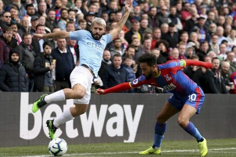 Manchester City's Sergio Aguero, left, and Crystal Palace's Andros Townsend  battle for the ball during their English Premier League soccer match at Selhurst Park, London, Sunday, April 14, 2019. (Steven Paston/PA via AP)