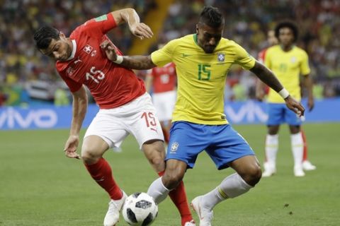Switzerland's Blerim Dzemaili, left, and Brazil's Paulinho struggle for the ball during the group E match between Brazil and Switzerland at the 2018 soccer World Cup in the Rostov Arena in Rostov-on-Don, Russia, Sunday, June 17, 2018. (AP Photo/Andre Penner)