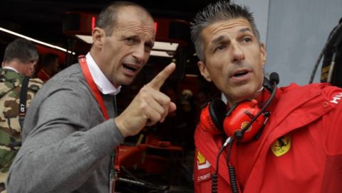 Former Juventus coach Massimiliano Allegri, left, speaks with Ferrari's technician during the second free practice at the Monza racetrack, in Monza, Italy, Friday, Sept. 6, 2019. The Formula one race will be held on Sunday. (AP Photo/Luca Bruno)