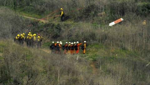 Firefighters work the scene of a helicopter crash where former NBA star Kobe Bryant died, Sunday, Jan. 26, 2020, in Calabasas, Calif. (AP Photo/Mark J. Terrill)