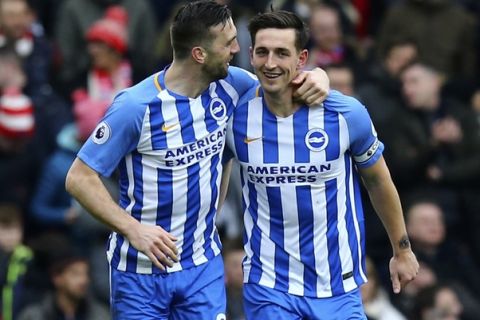 Brighton's Lewis Dunk, right, celebrates scoring his side's first goal of the game during the English Premier League soccer match between Brighton and Arsenal at the AMEX Stadium, in Brighton, England, Sunday March 4, 2018. (Gareth Fuller/PA via AP)