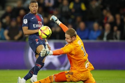 PSG's Kylian Mbappe kicks te ball as Strasbourg goalkeeper Matz Sels attempts to block his shot during the French League One soccer match between Paris-Saint-Germain and Strasbourg at the Parc des Princes stadium in Paris, France, Sunday, April 7, 2019. (AP Photo/Francois Mori)