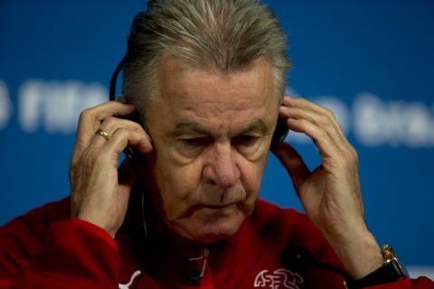 Switzerland's coach Ottmar Hitzfeld adjusts the headset during a news conference at Itaquerao Stadium in Sao Paulo, Brazil, Monday, June 30, 2014.  On Tuesday, Switzerland will face Argentina in their next World Cup soccer match. (AP Photo/Dario Lopez-Mills)