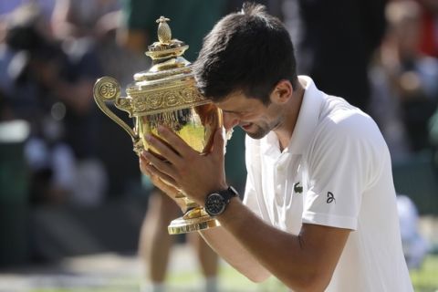 Serbia's Novak Djokovic holds the trophy after winning the men's singles final match against Kevin Anderson of South Africa, at the Wimbledon Tennis Championships, in London, Sunday July 15, 2018.(AP Photo/Kirsty Wigglesworth)