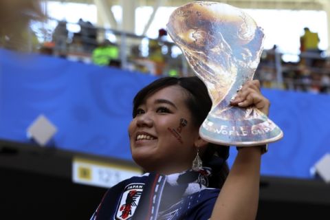 A fan of Japan shows a cut of the World Cup trophy prior to the group H match between Colombia and Japan at the 2018 soccer World Cup in the Mordavia Arena in Saransk, Russia, Tuesday, June 19, 2018. (AP Photo/Eugene Hoshiko)