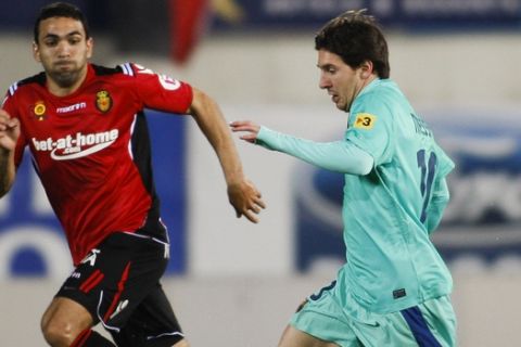 Barcelona's Lionel Messi from Argentina, right, runs with the ball next to Mallorca's Joao Victor from Brazil, left, during their Spanish La Liga soccer match at Iberostar stadium in Palma de Mallorca, Spain, Saturday, Feb. 26, 2011. (AP Photo/Manu Mielniezuk)