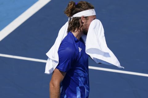 Stefanos Tsitsipas, of Greece, wipes his face during a third round men's tennis match against Ugo Humbert, of France, at the 2020 Summer Olympics, Wednesday, July 28, 2021, in Tokyo, Japan. (AP Photo/Patrick Semansky)
