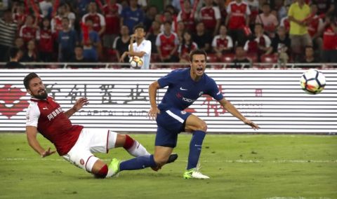 Arsenal's Olivier Giroud, left, kicks the ball past Chelsea's Cesar Azpilicueta during the second half of their friendly soccer match in Beijing, Saturday, July 22, 2017. Chelsea beat Arsenal 3-0. (AP Photo/Mark Schiefelbein)