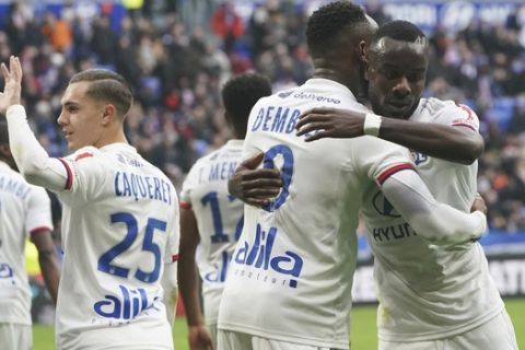 Lyon's Moussa Dembele, center, and Jean-Victor Makengo, right, celebrate after scoring their side's second goal during the French League One soccer match between Lyon and Toulouse in Decines, outside Lyon, central France, Sunday, Jan. 26, 2020. (AP Photo/Laurent Cipriani)