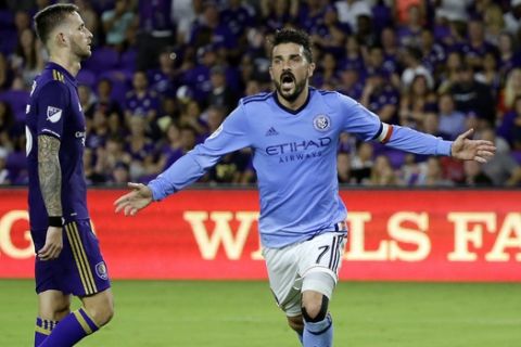 FILE - In this Sunday, May 21, 2017 file photo, New York City FC's David Villa celebrates his goal as he runs past Orlando City's Leo Pereira, left, in an MLS soccer game in Orlando, Fla. David Villa has been called up by Spain for the first time since the 2014 World Cup, giving the countrys record scorer a chance to add to his 59 international goals. (AP Photo/John Raoux, File)