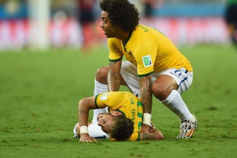 FORTALEZA, BRAZIL - JULY 04:  Neymar of Brazil lies on the field after a challenge as teammate Marcelo reacts during the 2014 FIFA World Cup Brazil Quarter Final match between Brazil and Colombia at Castelao on July 4, 2014 in Fortaleza, Brazil.  (Photo by Jamie McDonald/Getty Images)
