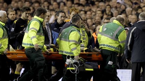 Bolton Wanderers' Fabrice Muamba is stretchered off the pitch after collapsing during the English FA Cup quarterfinal soccer match between Tottenham Hotspur and Bolton Wanderers at White Hart Lane stadium in London, Saturday, March 17, 2012. Bolton midfielder Fabrice Muamba has been carried off the field at Tottenham after medics appeared to be trying to resuscitate him during an FA Cup quarterfinal that was abandoned. Muamba went to the ground in the 41st minute with no players around him and the game was immediately stopped. (AP Photo/Matt Dunham)