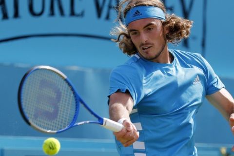Stefanos Tsitsipas of Greece returns to Jeremy Chardy of France during their singles match at the Queens Club tennis tournament in London, Thursday, June 20, 2019.(AP Photo/Frank Augstein)