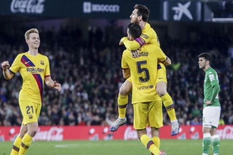 Barcelona's Sergio Busquets is congratulated by teammate Leo Messi after scoring during La Liga soccer match between Betis and Barcelona at the Benito Villamarin stadium in Seville, Spain, Sunday, Feb. 9, 2020. (AP Photo/Miguel Morenatti)