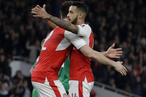 Arsenal's Theo Walcott, right, is congratulated by teammate Olivier Giroud after scoring a goal during the English FA Cup quarterfinal soccer match between Arsenal and Lincoln City at the Emirates stadium in London, Saturday, March 11, 2017. (AP Photo/Matt Dunham)