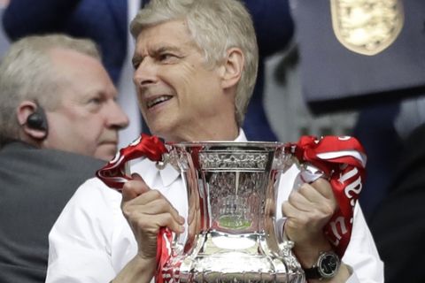 Arsenal team manager Arsene Wenger holds the trophy after winning the English FA Cup final soccer match between Arsenal and Chelsea at the Wembley stadium in London, Saturday, May 27, 2017. (AP Photo/Matt Dunham)