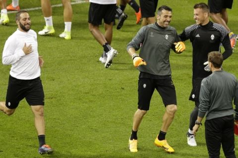 Juventus' Gonzalo Higuain, left, goalkeeper Gianluigi Buffon, center, and Neto attends a training session at the Millennium Stadium in Cardiff, Wales Friday June 2, 2017. Real Madrid will play Juventus in the final of the Champions League soccer match in Cardiff on Saturday. (AP Photo/Alastair Grant)