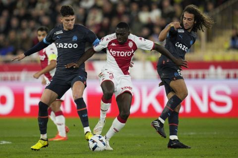 Marseille's Leonardo Balerdi, left, and Matteo Guendouzi, right, challenge for the ball with Monaco's Youssouf Fofana during the French League One soccer match between Monaco and Marseille at the Stade Louis II in Monaco, Sunday, Nov. 13, 2022. (AP Photo/Daniel Cole)