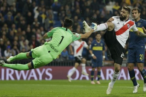Argentina's Boca Juniors goalkeeper Esteban Andrada punches the ball away from Lucas Pratto of Argentina's River Plate during the Copa Libertadores final soccer match at the Santiago Bernabeu stadium in Madrid, Spain, Sunday, Dec. 9, 2018. (AP Photo/Thanassis Stavrakis)