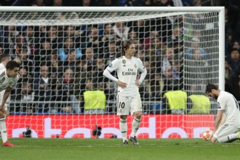 Real Madrid player reacts as Ajax's Dusan Tadic celebrates scoring his side's 3rd goal, during the Champions League soccer match between Real Madrid and Ajax at the Santiago Bernabeu stadium in Madrid, Spain, Tuesday, March 5, 2019. (AP Photo/Manu Fernandez)