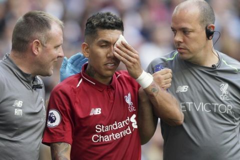 Liverpool's Roberto Firmino, holds a patch over his eye after he received a treatment during the English Premier League soccer match between Tottenham Hotspur and Liverpool at Wembley Stadium in London, Saturday Sept. 15, 2018. (AP Photo/Tim Ireland)