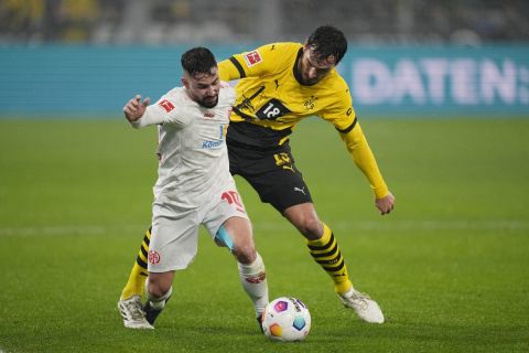 Dortmund's Mats Hummels, right, fights for the ball with Mainz's Marco Richter during the German Bundesliga soccer match between Borussia Dortmund and 1. FSV Mainz 05 at the Signal-Iduna Park in Dortmund, Germany, Tuesday, Dec. 19, 2023. (AP Photo/Martin Meissner)