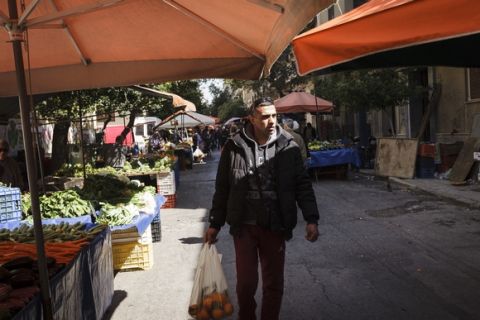 Ibrahim al-Hussein walks past street vendors selling fruit and vegetables at a public market near his house in Kypseli. ; Ibrahim al-Hussein will carry the Olympic Flame in Athens as part of the torch relay for the 2016 Games in Rio de Janeiro.
The symbolic gesture is meant to show solidarity with the worlds refugees at a time when millions are fleeing war and persecution worldwide and an its an immense privilege for the a 27 year old refugee from Syria who once dreamed of competing in the Olympics and whose athletic career was interrupted by the war and an injury that cost him part of his right leg after a bombing in his home town of Deir ez-Zor.
"It is an honor," Ibrahim says of bearing the Olympic flame. "Imagine achieving one of your biggest dreams. Imagine that your dream of more than 20 years is becoming a reality."  
Ibrahim commits himself to a rigorous training schedule. Three days per week, He swims with ALMA, a Greek nonprofit organization for athletes with disabilities. His training is held in the former 2004 Olympic sport complex in Athens. He is also part of a wheelchair basketball league that meets five times per week and travels throughout the country for games. 
Ibrahim does all this despite working a 10-hour overnight shift at a cafe in Anthoupoli, an Athens suburb 30 minutes by train from his home. 
"It's not just a game for me," Ibrahim says of his commitment to athletics. "It's my life."