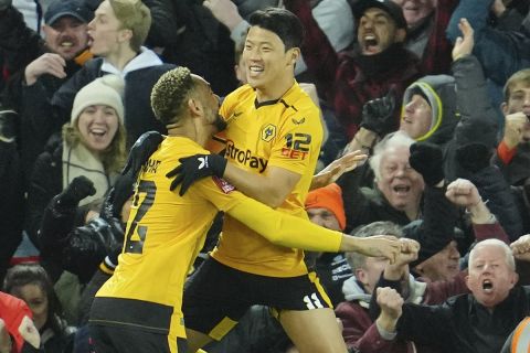 Wolverhampton Wanderers' Hwang Hee-chan, right, celebrates after scoring his side's second goal during the English FA Cup soccer match between Liverpool and Wolverhampton Wanderers at Anfield in Liverpool, England Saturday, Jan. 7, 2023 (AP Photo/Jon Super)